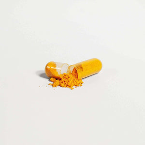 Open capsule of yellow powdered MIANIMED premium skincare supplement.