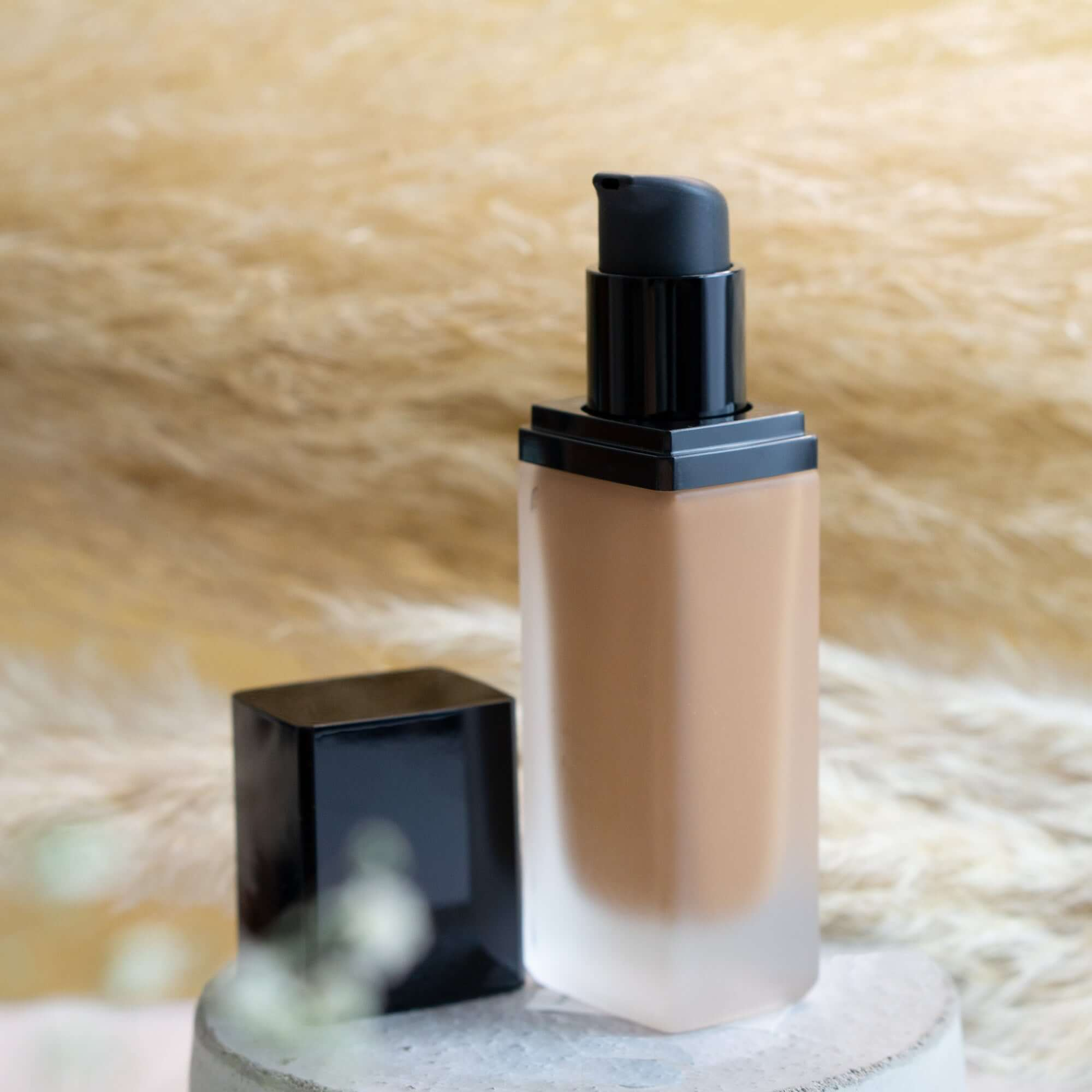 MIANIMED premium skincare foundation bottle with black cap on a textured background.