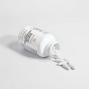 MIANIMED premium skincare probiotics capsules spilling from a white bottle, representing high-quality dietary supplements for skin health.