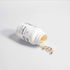 MIANIMED Premium Vitamin D3 supplement bottle on its side with capsules spilling out, representing premium skincare nutrients.